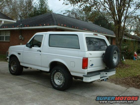 1996 Ford Bronco parked in driveway, rear view with spare tire mounted on back