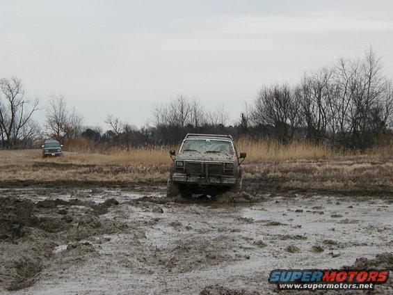 Two SUVs stuck in mud, one in the foreground, the other further back