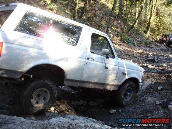 White 1993 Ford Bronco navigating a rocky off-road trail