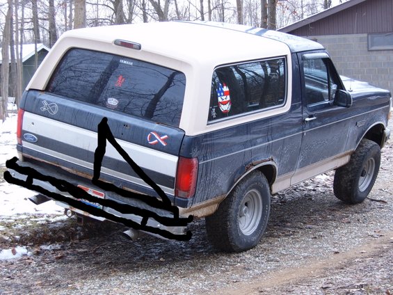 Dark blue and tan Ford Bronco with a white roof, seen from the rear