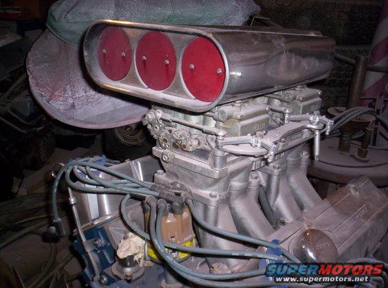 V8 engine block with Holley carburetors and a chrome air cleaner with three red filters
