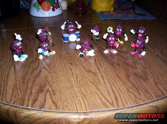 California Raisins figurines posed on a wooden table, some playing instruments
