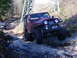 1990 Ford Bronco - Two off-road vehicles navigate a challenging rocky path near a power line tower.