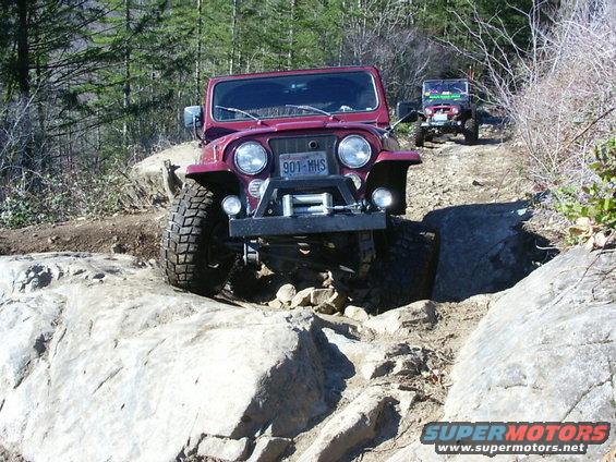 Red Jeep CJ-7 with winch on rocky trail, license plate 901-MHS