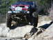 1990 Ford Bronco - This off-road vehicle navigates a rocky trail, its powerful suspension and aggressive tires.