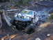 1990 Ford Bronco - Off-road vehicle with custom bumper and large tires navigating a challenging muddy trail.