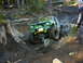 1990 Ford Bronco - A modified off-road vehicle tackles a challenging muddy terrain with a person watching.