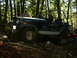 1990 Ford Bronco - Jeep CJ-7 navigates a wooded trail, showing its off-road capabilities.