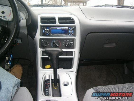 Car interior showing dashboard, steering wheel, gear shifter, and radio