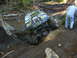 1990 Ford Bronco - Off-road vehicle navigating a difficult muddy terrain, with a person observing.