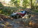 1990 Ford Bronco - A red Jeep CJ-7 tackles a challenging muddy off-road course, with its driver looking on.
