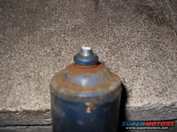 Blue shock absorber with rust and a silver top, showing Supermotors.net logo