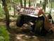 1975 Ford Bronco - A red 1975 Ford Bronco navigates a challenging muddy off-road course.