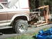 1982 Ford Bronco - The engine has been removed from this Ford Bronco and is being supported by an engine hoist. The front passenger tire is flat.