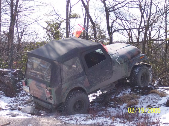 Camouflaged Jeep Wrangler on snowy, rocky terrain. Date stamp reads 02/19/2005