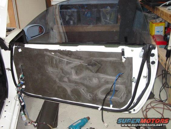 Car door panel removed, showing wiring and insulation