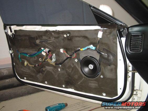 Car door interior with speaker and exposed wiring
