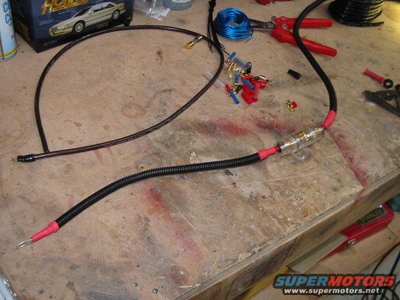 Car audio wiring with a fuse holder and various connectors on a workbench