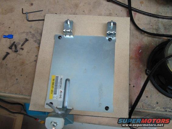 Metal electronic control unit with yellow label F32F-18789E-HB and part number 9415, mounted on wood