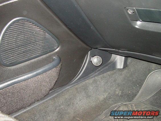 Car interior shot showing a speaker grille and a lock cylinder near the dashboard