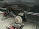 1981 Chevrolet C/K Pickup - The rear suspension and axle of a vehicle are visible, supported by jack stands and blocks, with tools scattered around.