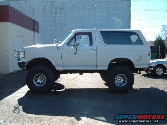 Lifted white Ford Bronco parked next to another vehicle