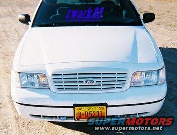 White 2000 Ford Crown Victoria front view with a blue 'zwack&' sticker on windshield