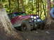 1990 Ford Bronco - This Jeep CJ-7 is navigating a difficult off-road path, getting stuck between two large trees.