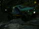 1990 Ford Bronco - A modified green truck navigates a challenging rocky path in a wooded area.