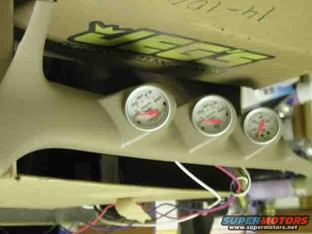 Tan gauge pod with three circular gauges, wires visible below