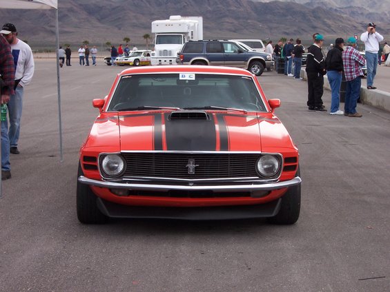 Red 1970 Ford Mustang front view with black hood stripes and a chrome grille