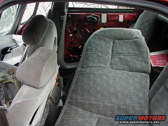 Interior view of a car with damaged door panel and torn upholstery