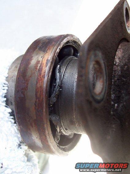 close-up of a damaged wheel bearing with rust and grease