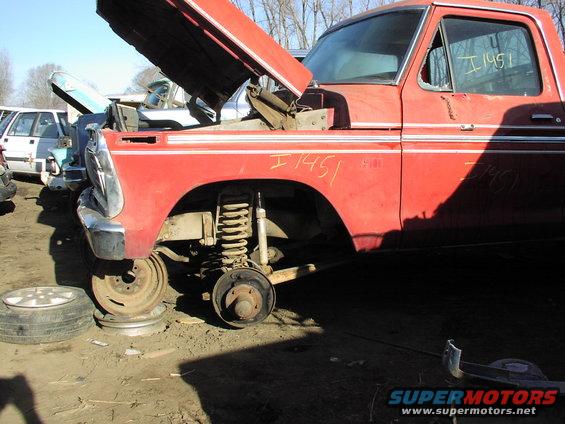 Red pickup truck with hood open, missing front wheels, and body trim