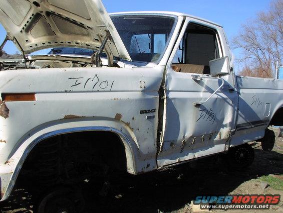 White 1981 Ford Bronco with hood open, showing rust and damage