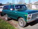 1978 Ford Bronco - A green 1978 Ford Bronco is parked on a driveway next to a lawn.