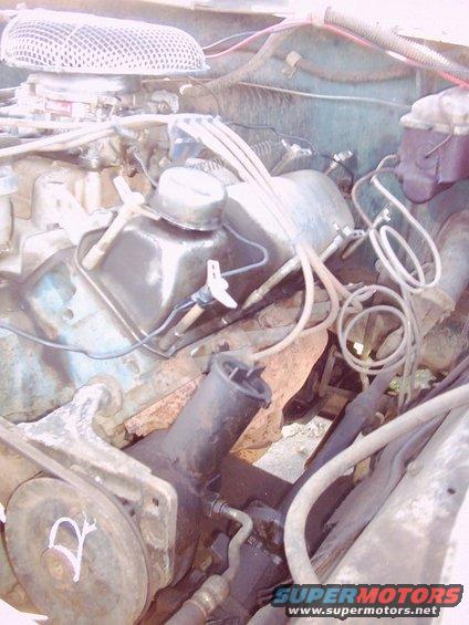 Engine bay of a 1978 Ford Bronco with a V8 engine, air cleaner, and various hoses and wires visible