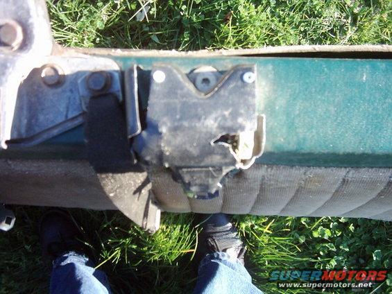 Green vehicle door latch mechanism with visible wear