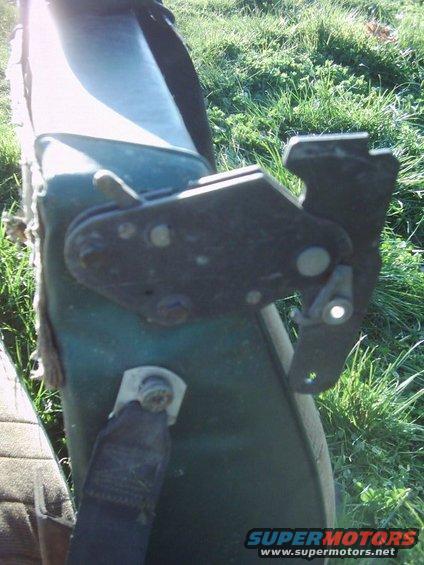 close-up of a seatbelt latch mechanism on a green surface