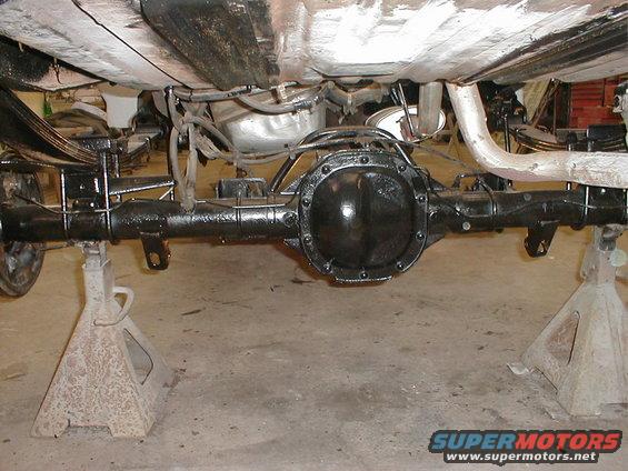 rear axle assembly on jack stands, showing leaf springs and exhaust pipe