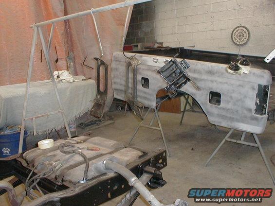 Truck bed and fuel tank in a workshop, prepped for paint