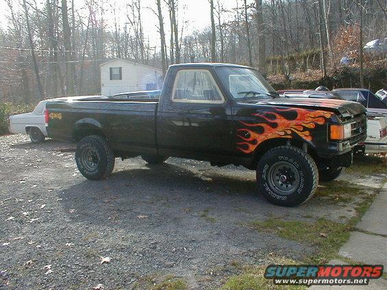 Black 1991 Ford F-150 with flame decals on the front fender and hood