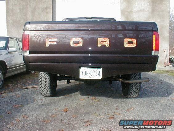 1991 Ford F-150 tailgate with custom wood-grain letters spelling FORD, license plate YJG-8754