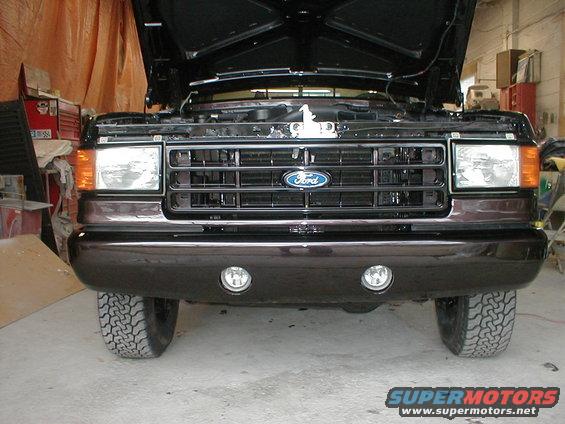 Dark brown 1987 Ford F-150 front grille and bumper with hood open. Fog lights visible