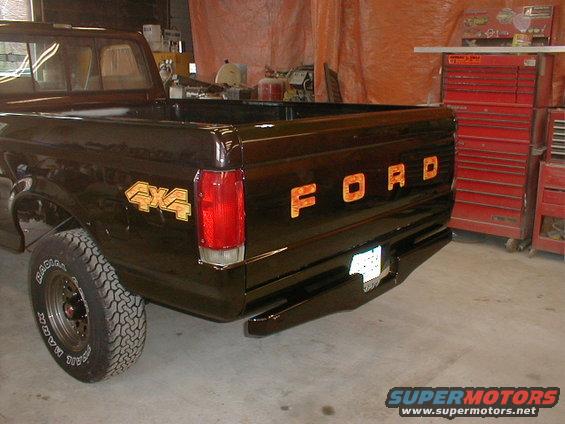 Dark brown 1991 Ford F-150 pickup truck rear view with gold 4x4 and FORD badging