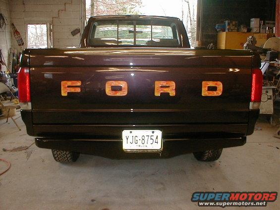 Dark brown 1991 Ford F-150 truck rear view with flame-painted tailgate letters and license plate YJG-8754
