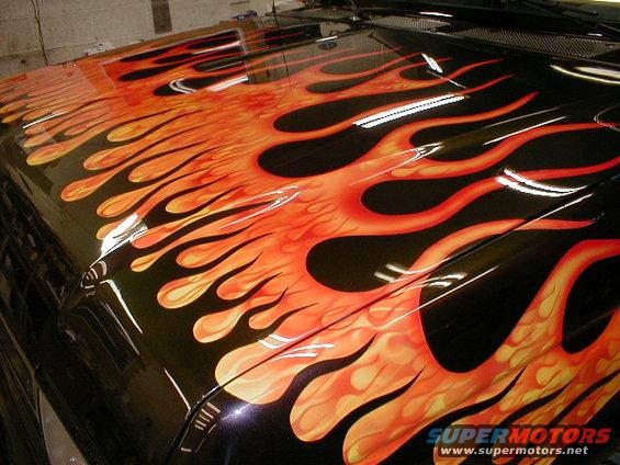 Black hood with orange and yellow flame graphics. A Supermotors.net watermark is visible