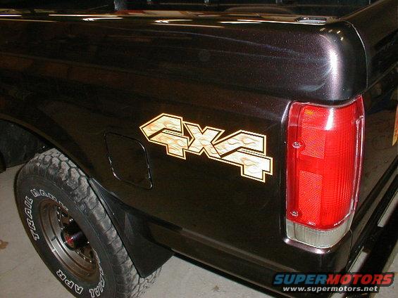 Black pickup truck rear with 4x4 flame decal and red taillight