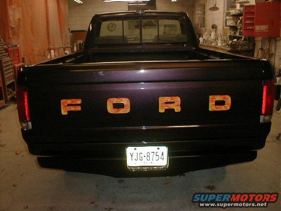 1991 Ford F-150 pickup truck rear with flame decals on tailgate letters and license plate YJG-8754
