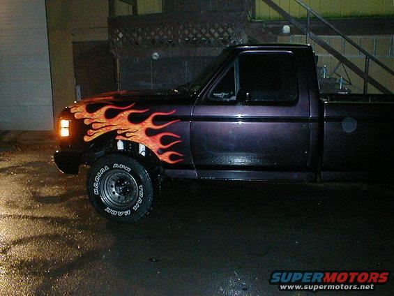1991 Ford F-150 pickup truck with custom flame paint on the hood and fender